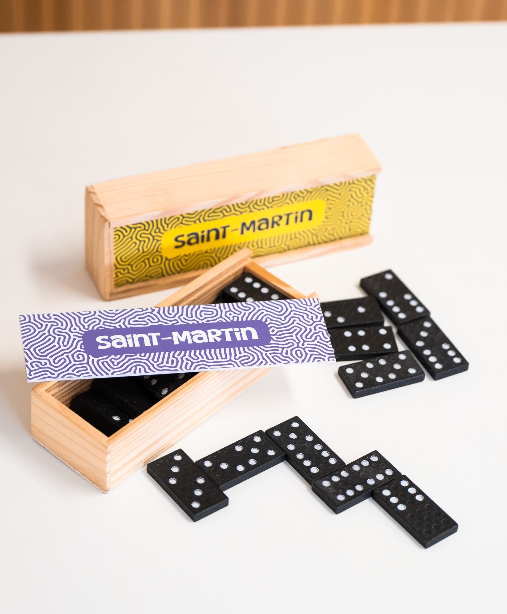 Un jeu de dominos dans une boîte en bois sur une table.