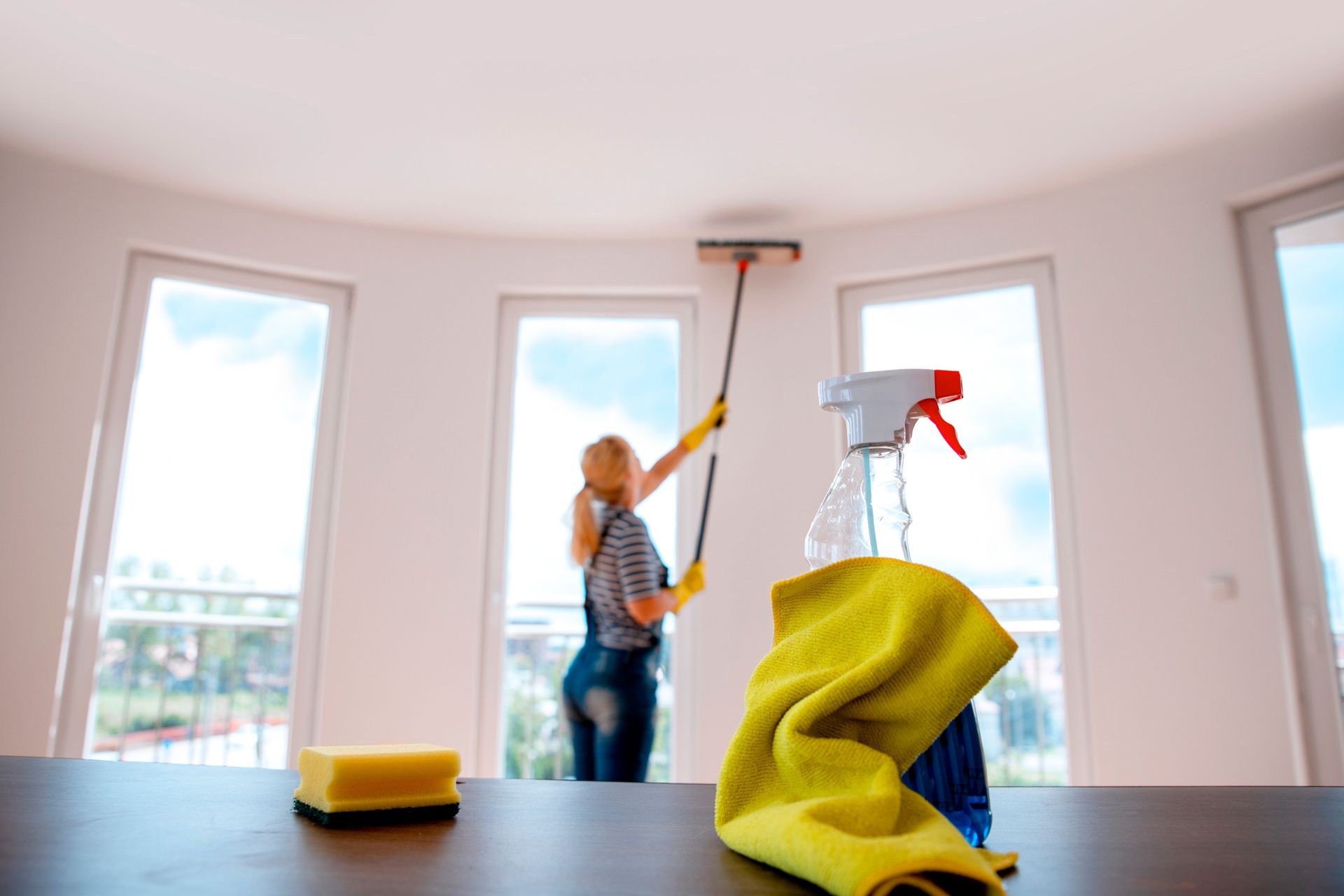 Woman cleaning a window with a squeegee. 