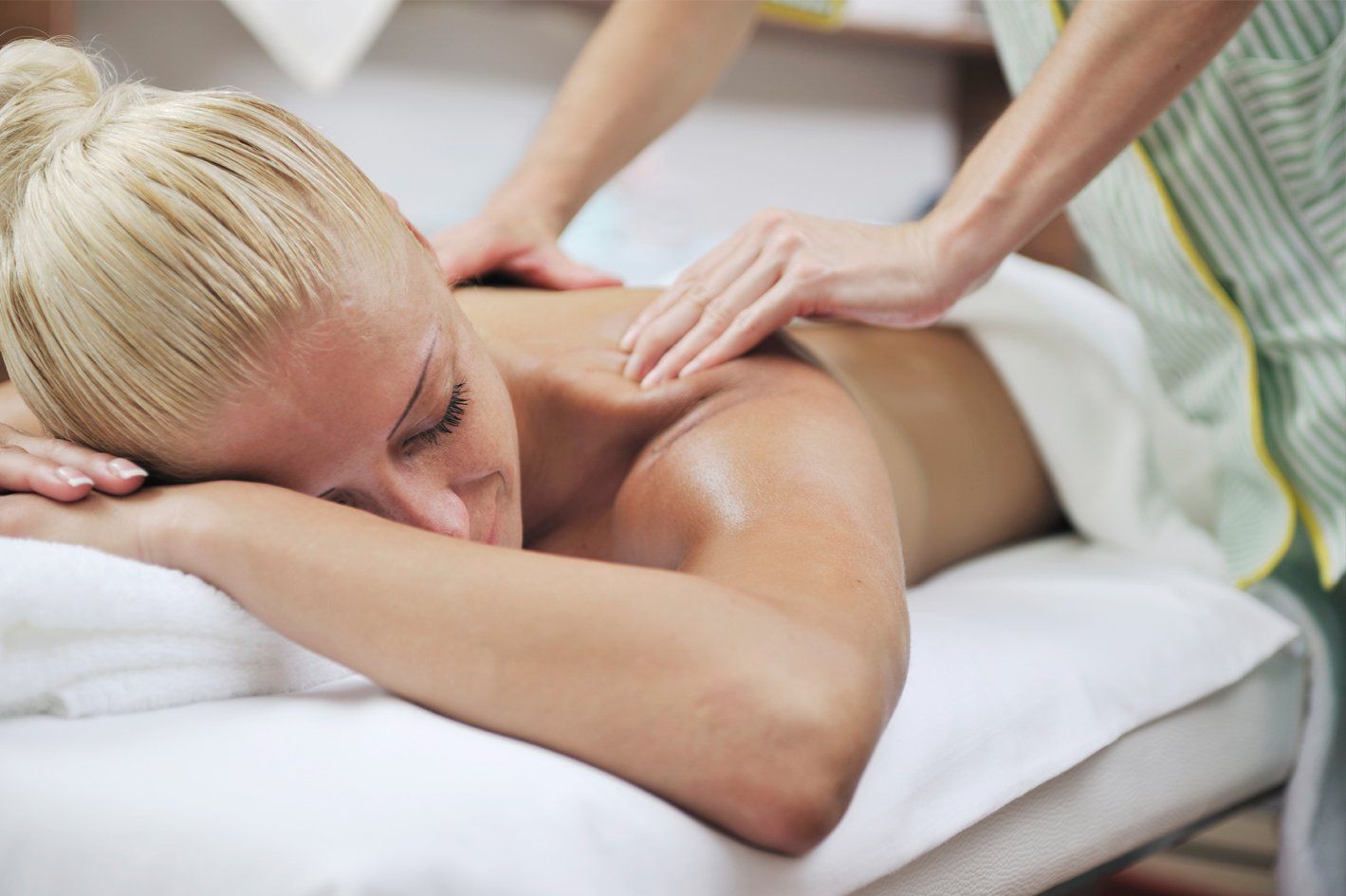 A woman is laying on a massage table getting a massage.
