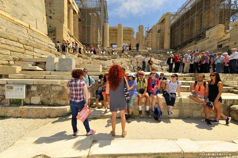 A guide leading a group of tourists at the Acropolis in Athens.