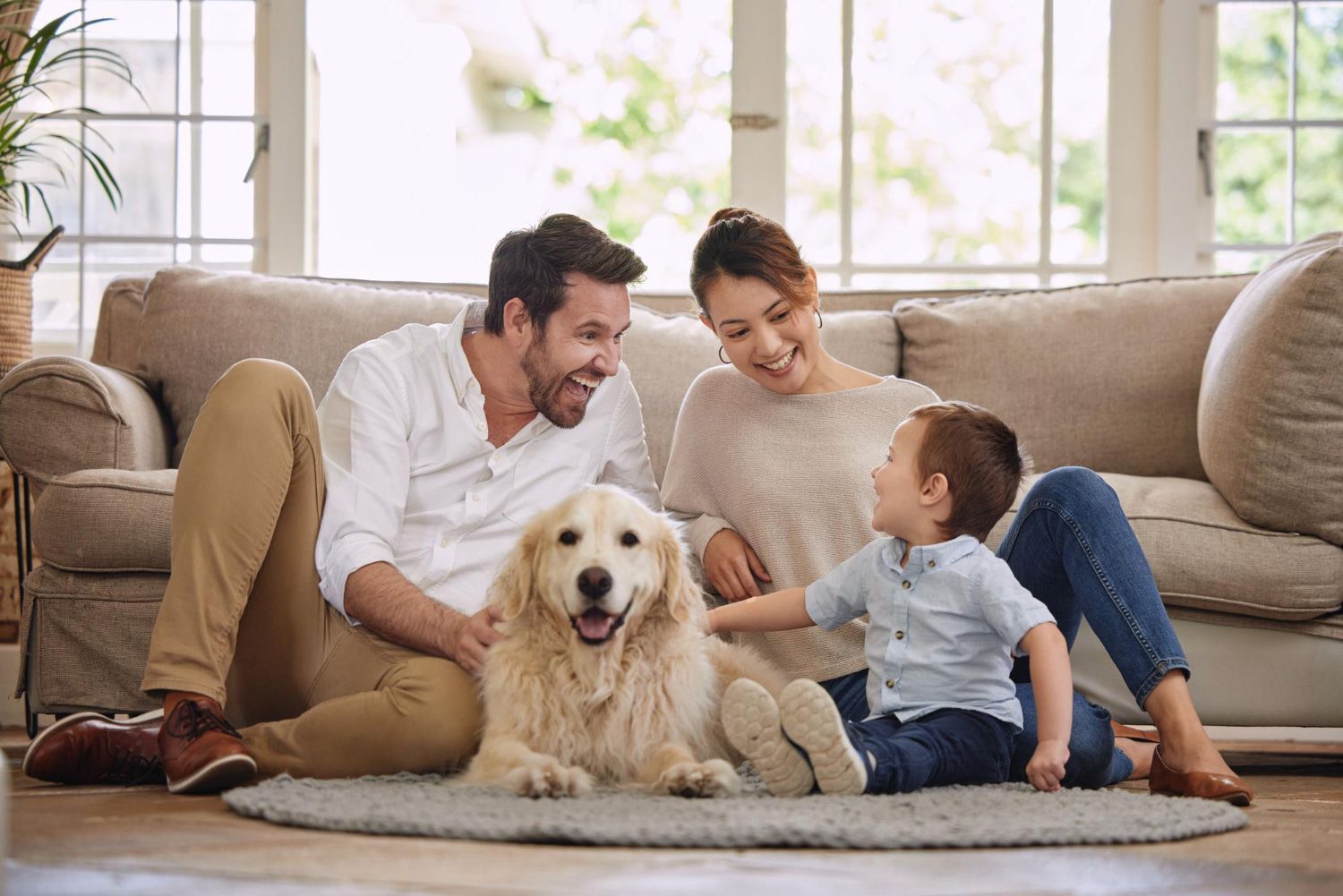 A family is sitting on a couch with a dog.