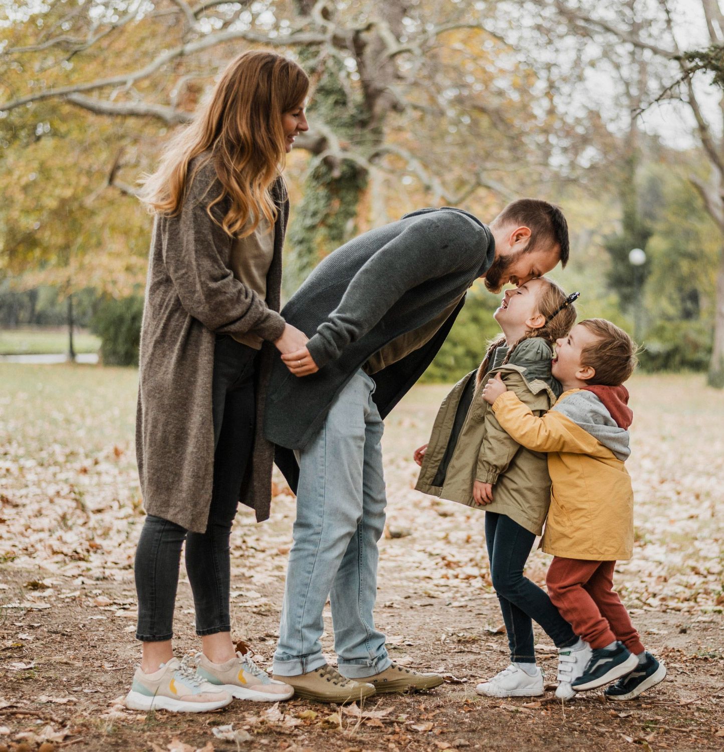 A family is standing next to each other in a park.