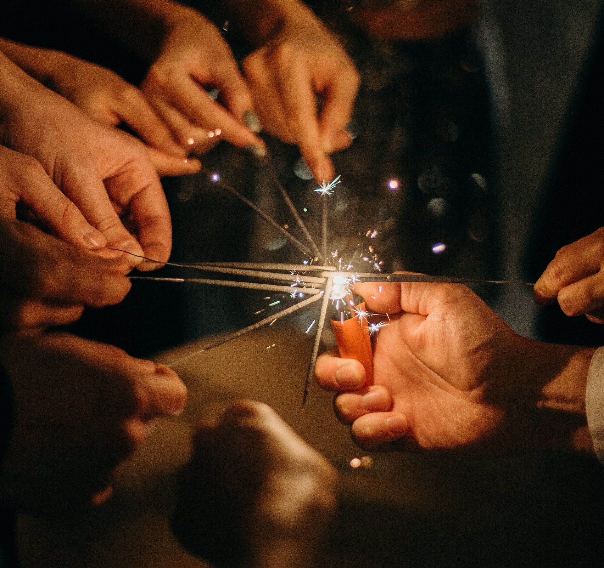 A group of people are holding sparklers in their hands.