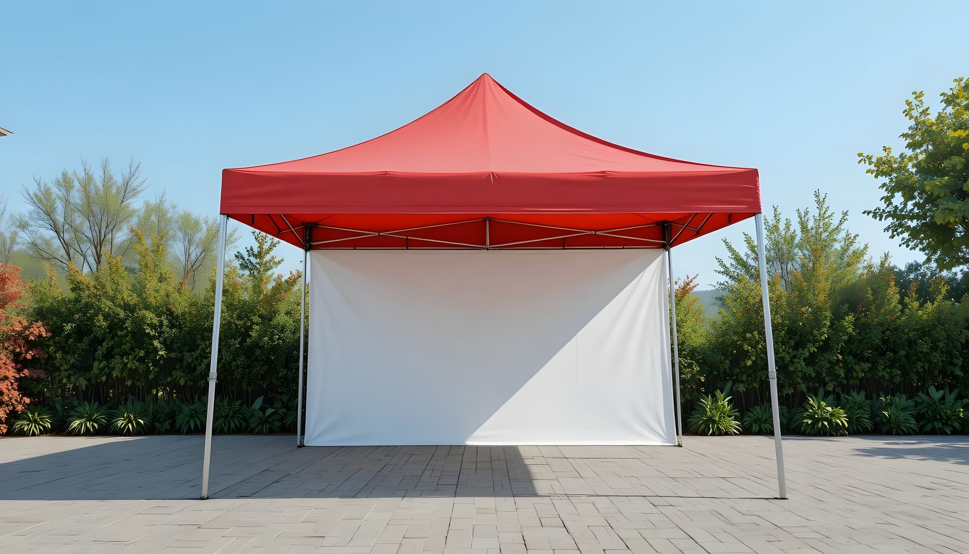 Red canopy tent with white backdrop set up outdoors.