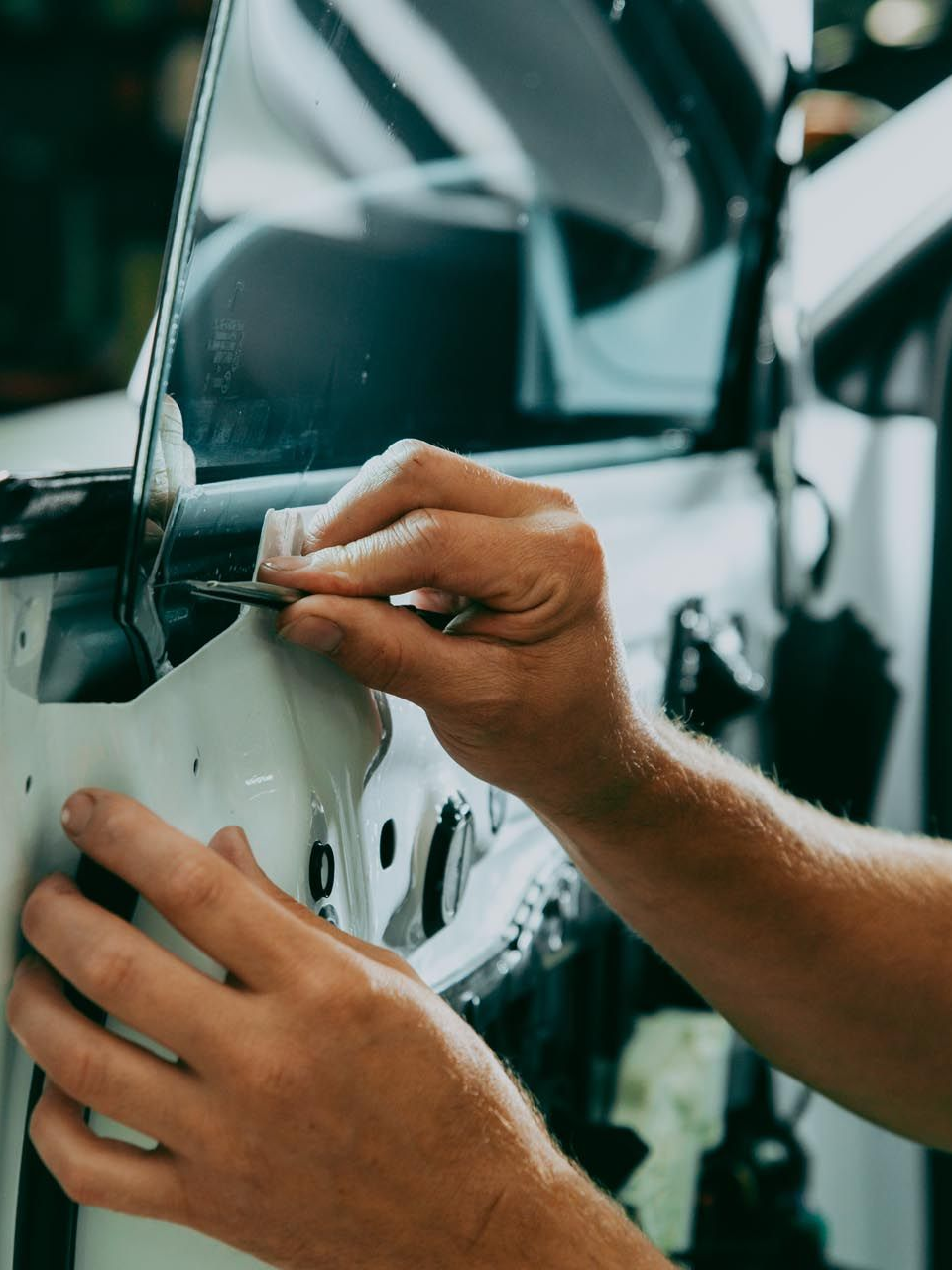 Silver car headlight covered in clear protective film.