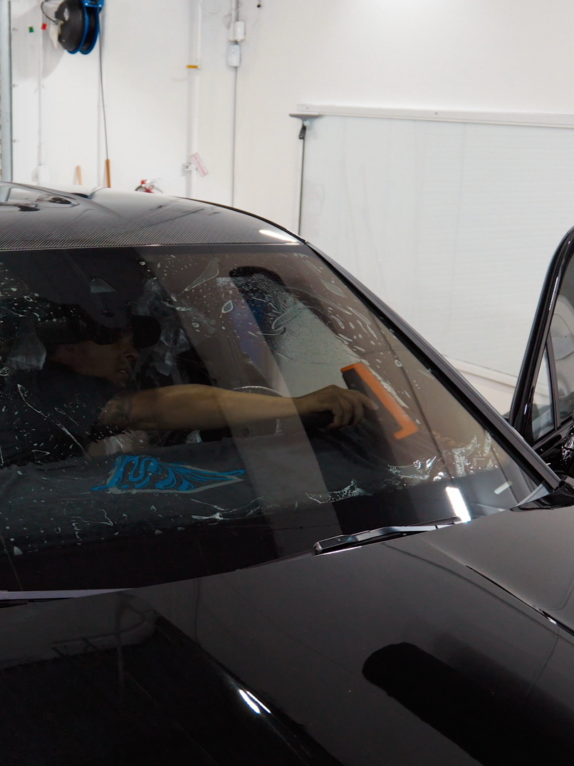 Raindrops on a dark, shiny car hood.