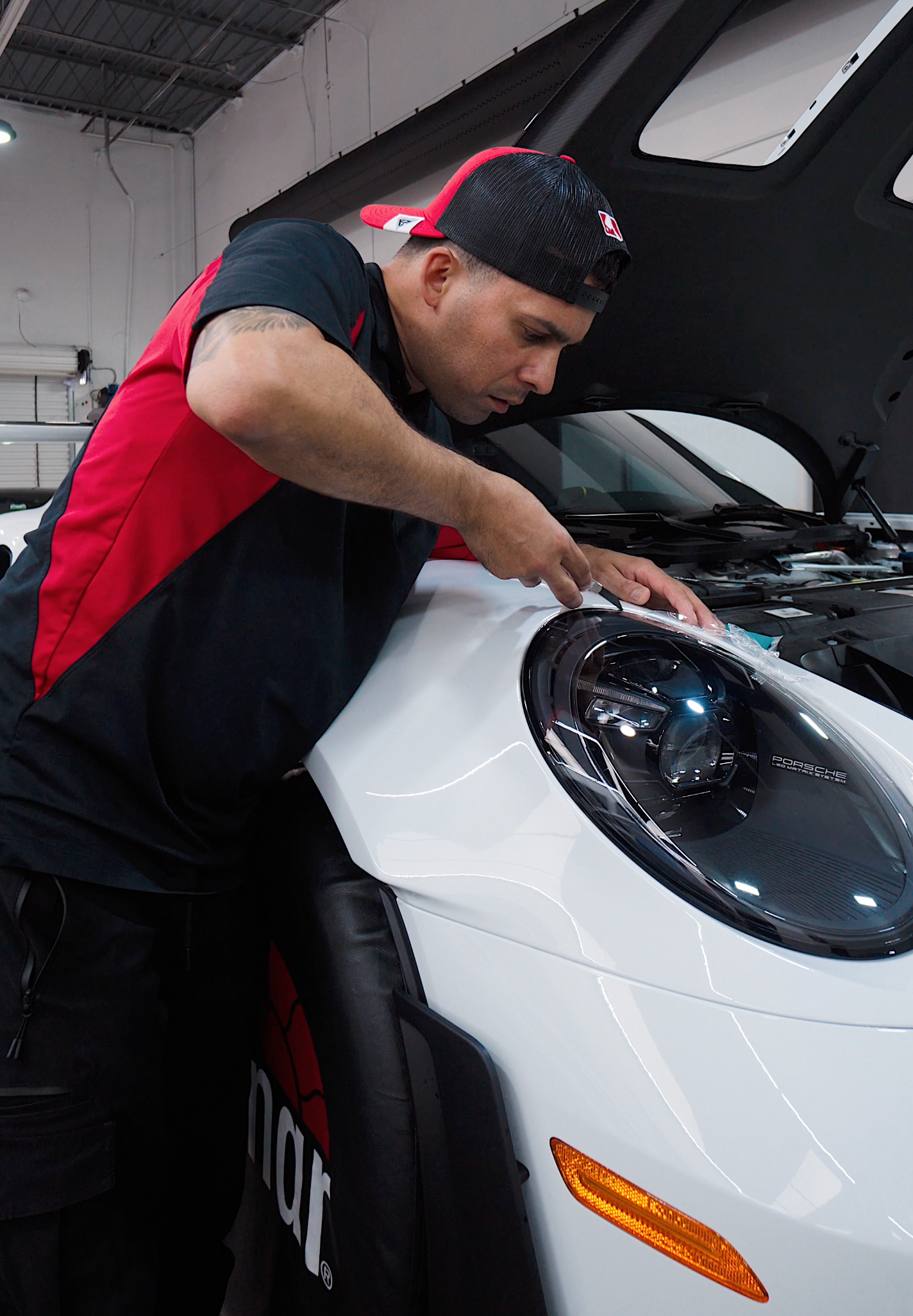 A silver car is being washed with soap and water