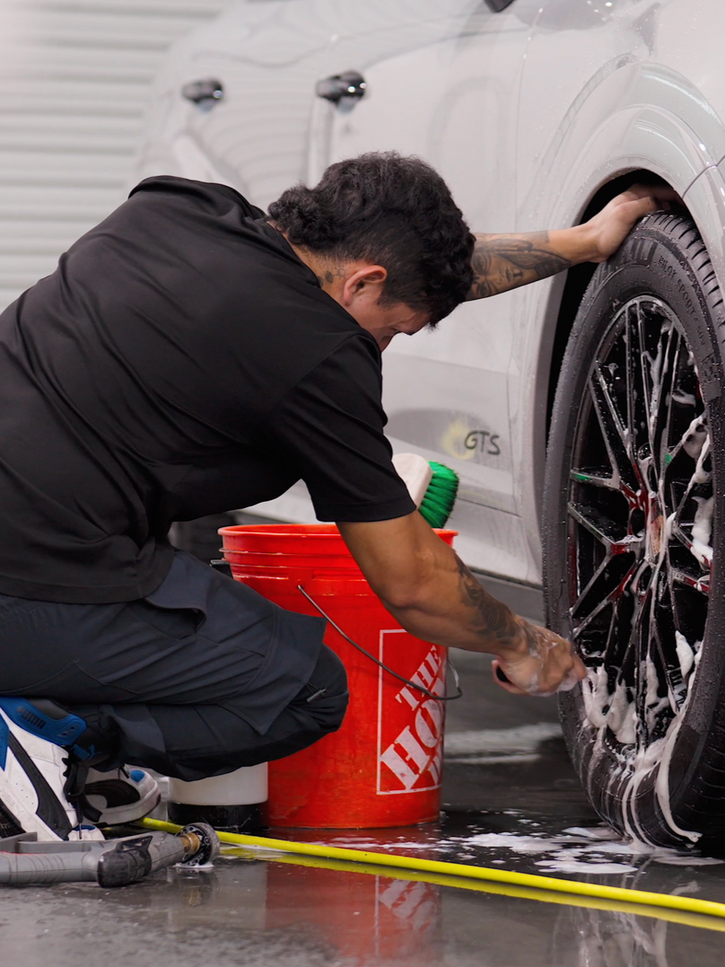 A person is wrapping a car with clear plastic