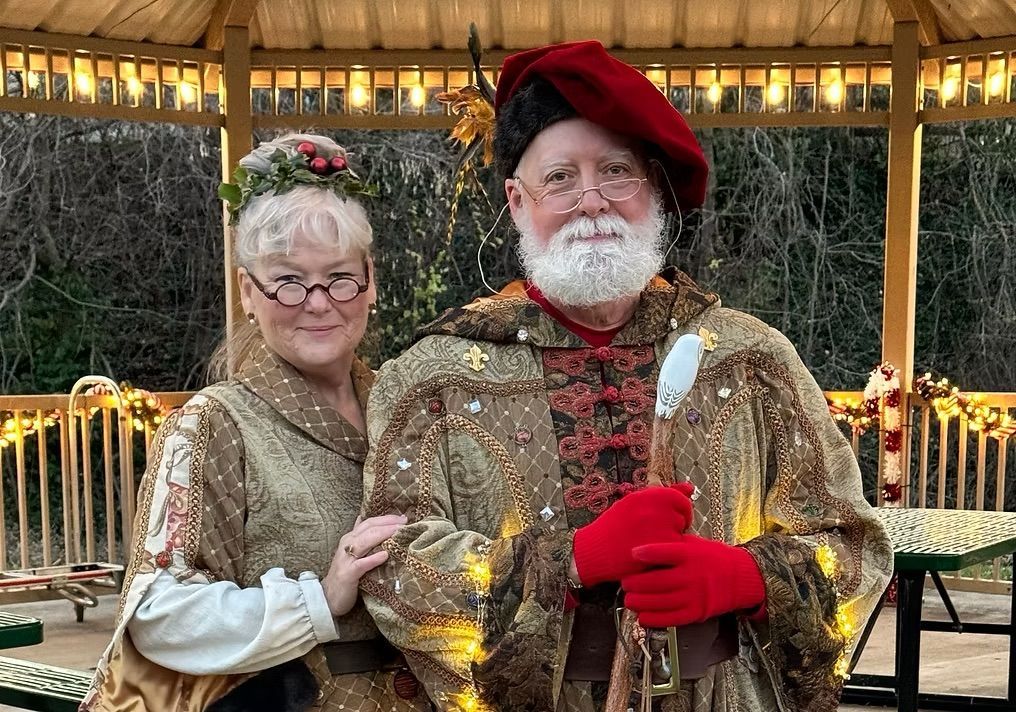 A man and a woman are posing for a picture in front of a gazebo.