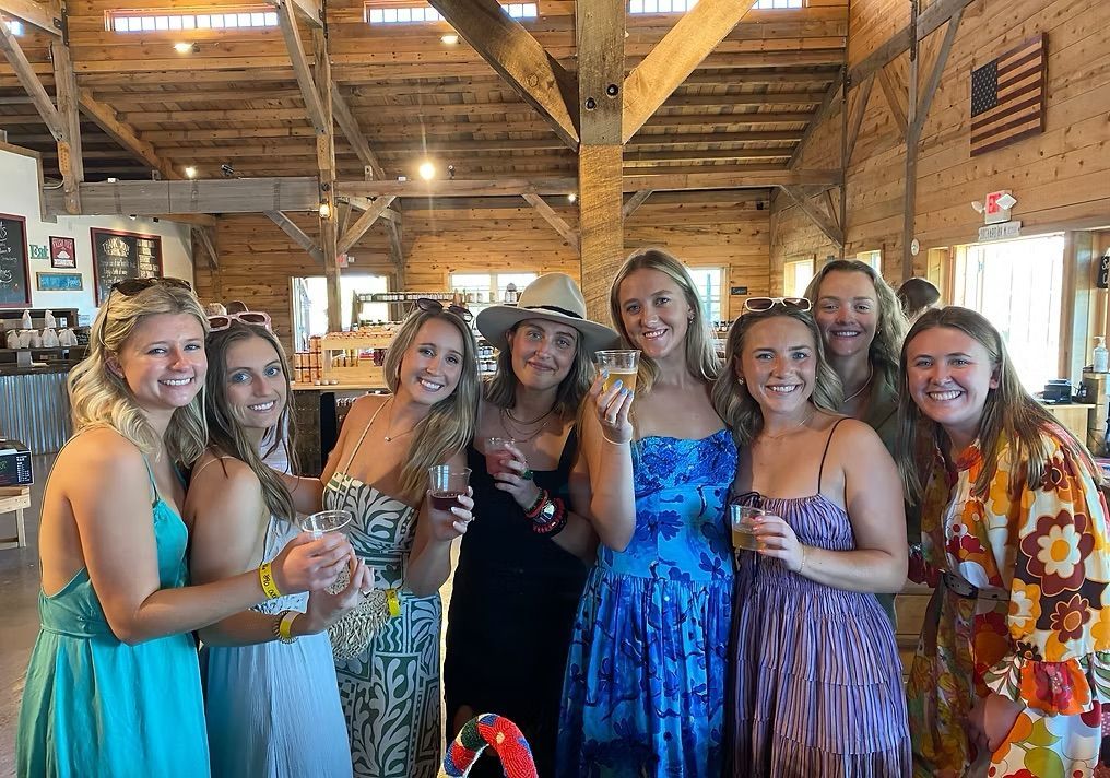 A group of women are standing next to each other holding wine glasses.