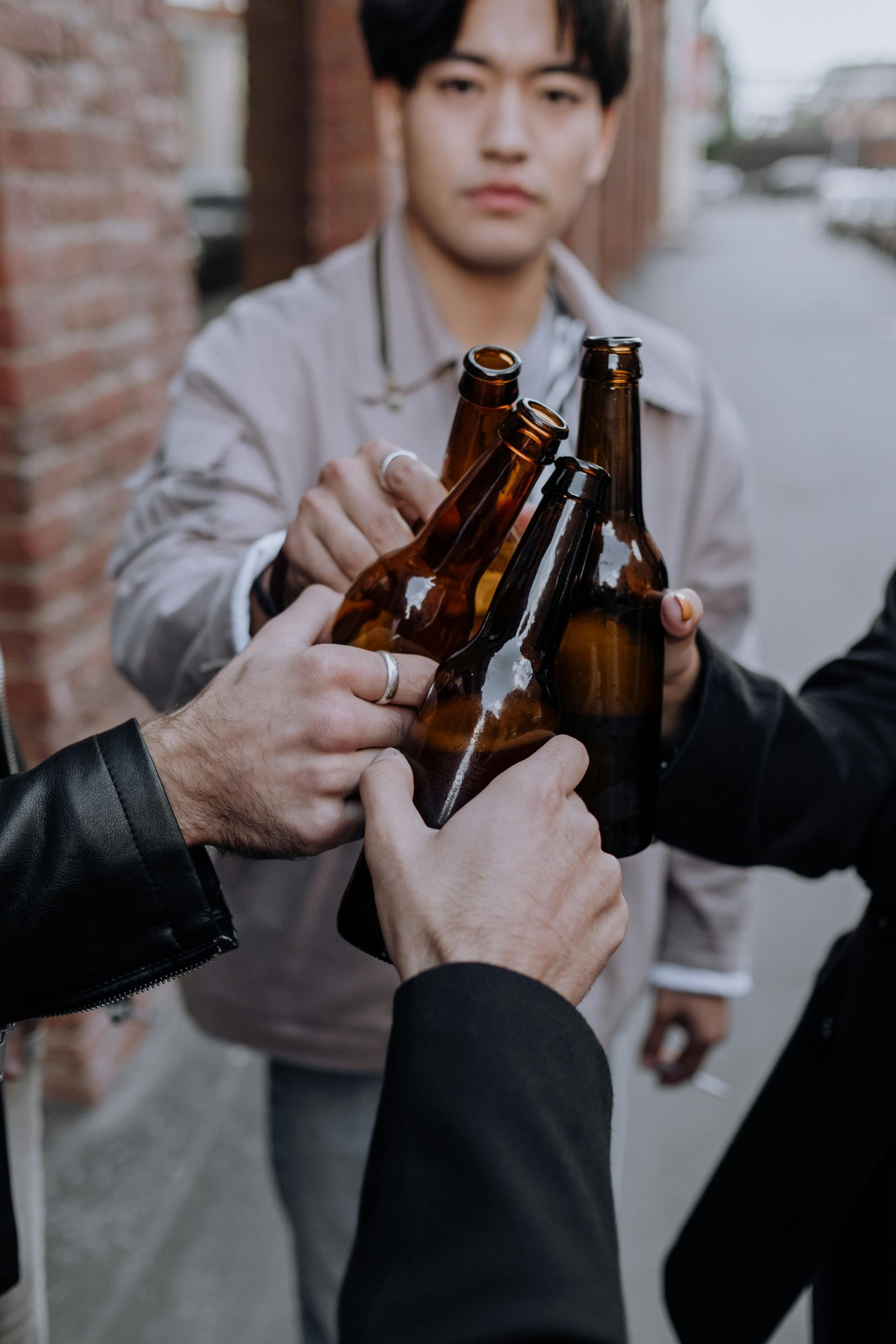 A group of men are toasting with beer bottles.