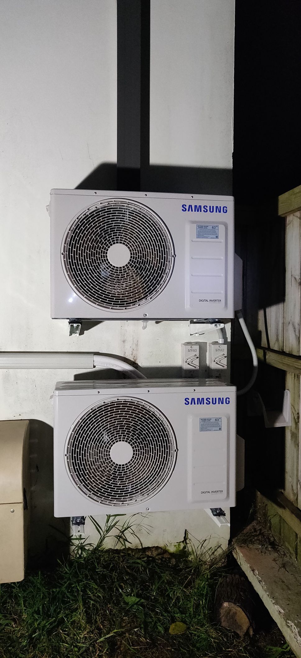 Two white air conditioning units mounted on an exterior wall in Nowra