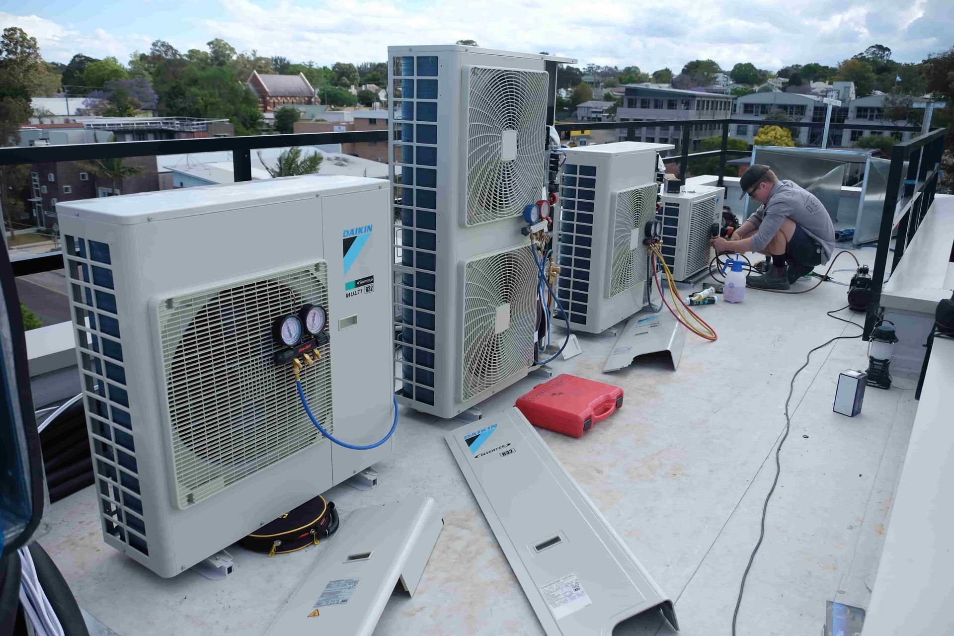 Denali Air Conditioning working on AC units on a rooftop in Nowra; several units are lined up.