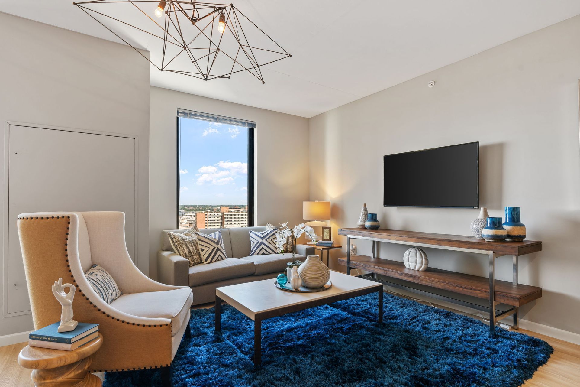 A living room with a couch , chair , coffee table and television.