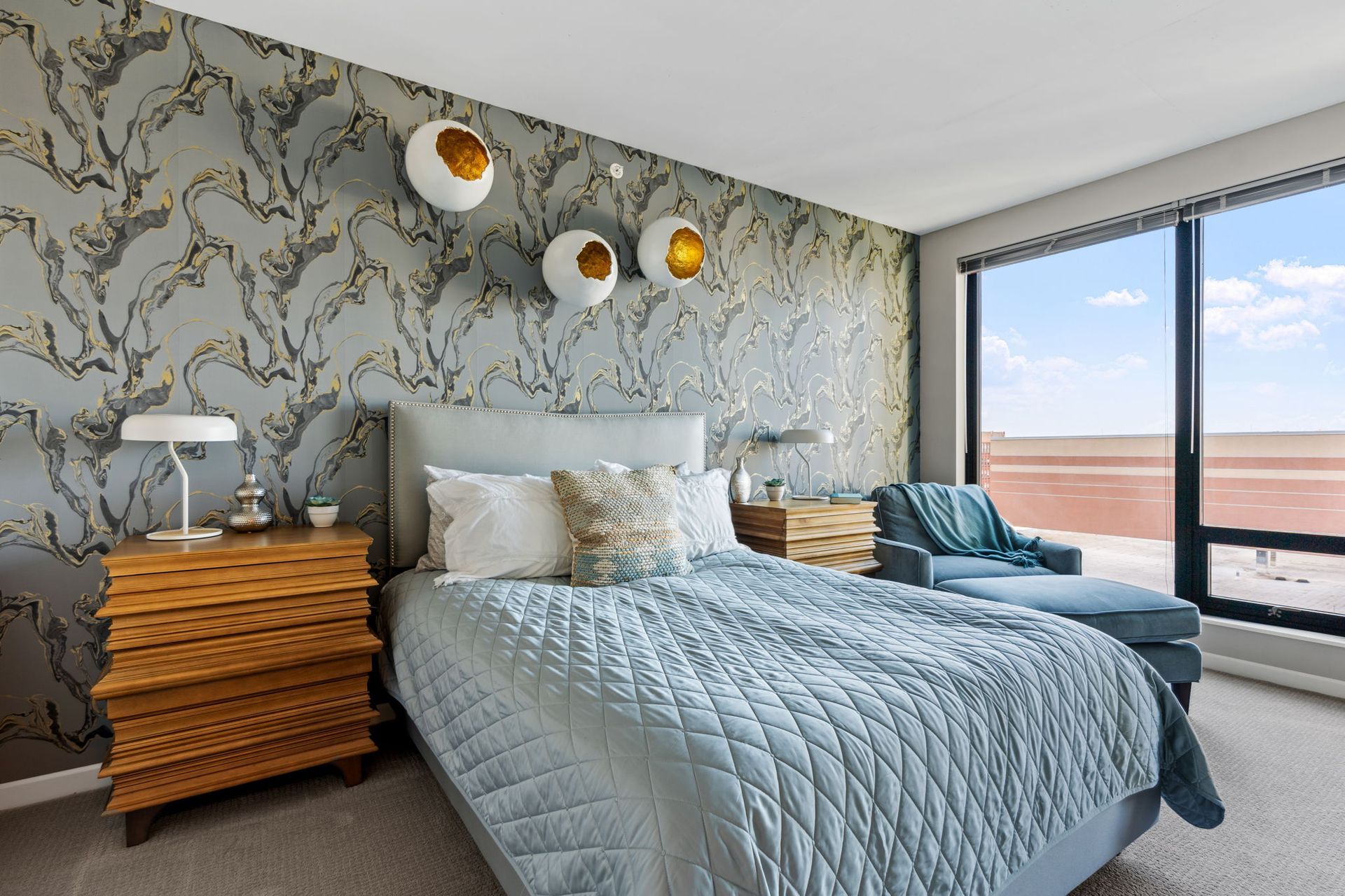 A bedroom with a bed , nightstand , chair and window.