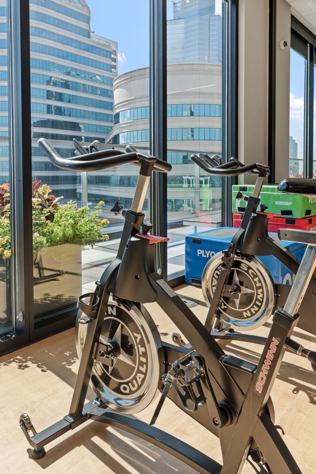 A gym with a lot of windows and exercise bikes.