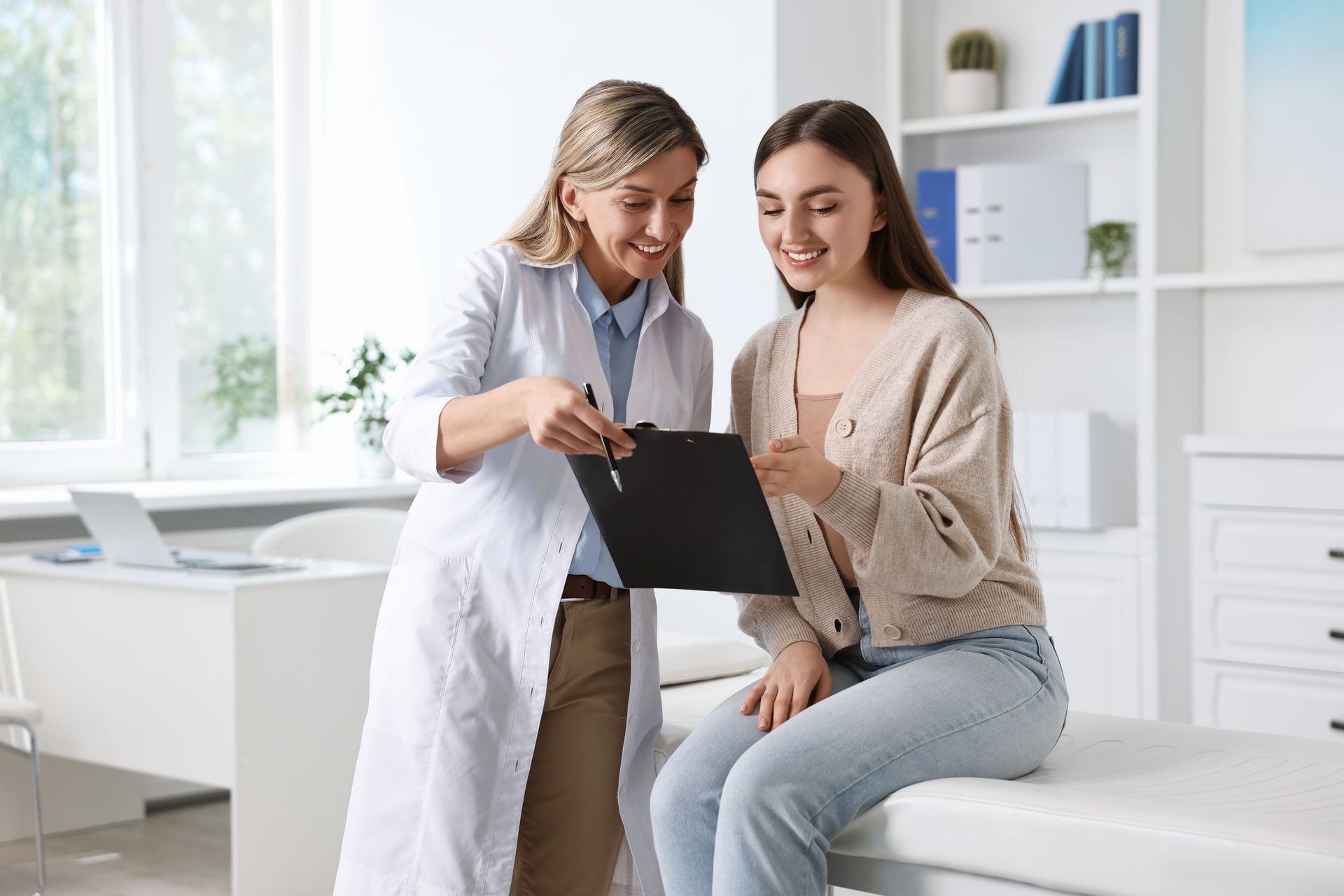 Doctor showing paperwork to a patient in a medical office. Both are smiling.