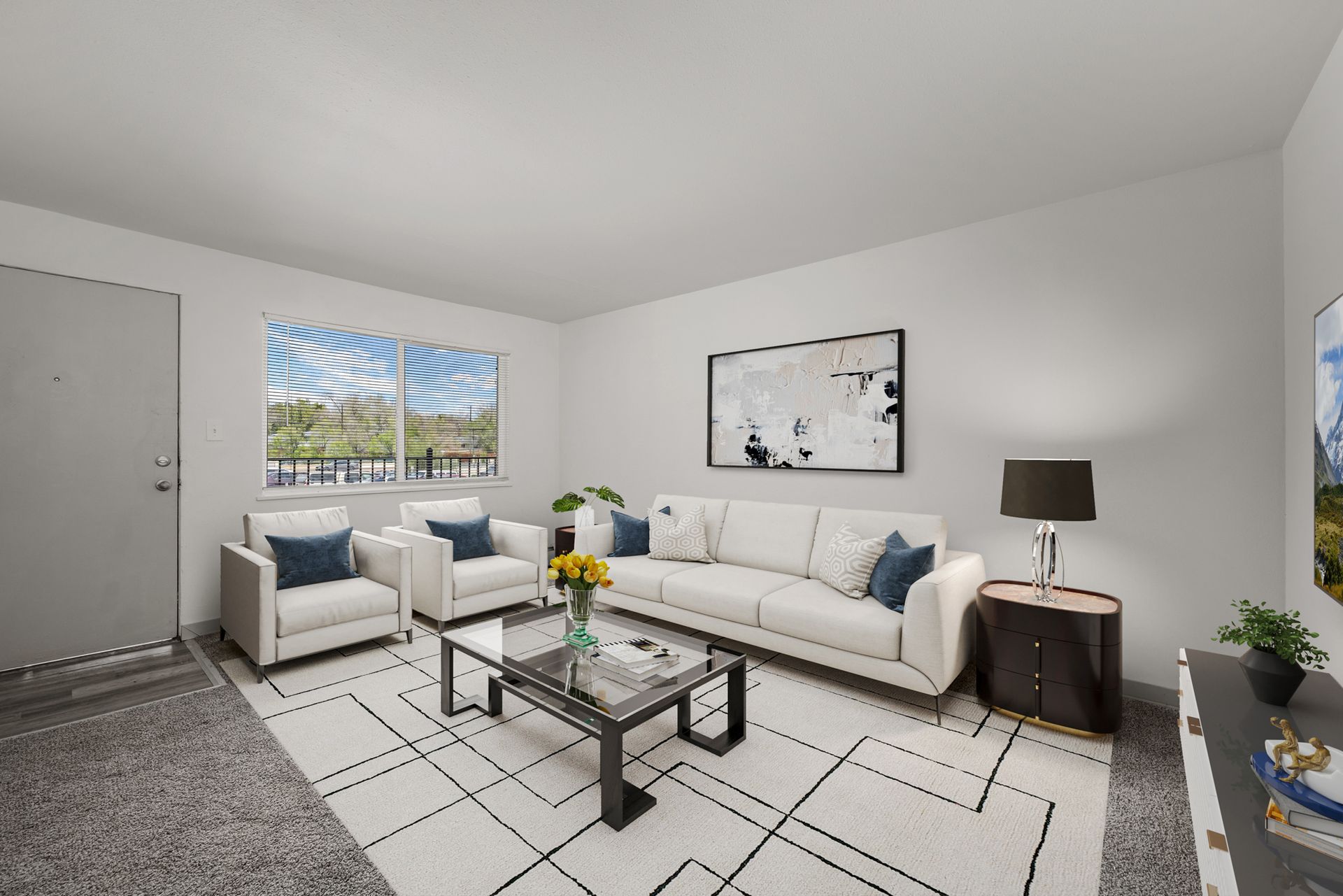 Photo showing a living room with space for a couch, a couple of chairs, a table and more