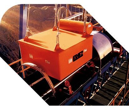 Máquina industrial roja con la parte superior naranja sobre una cinta transportadora o plataforma en un entorno de fábrica.