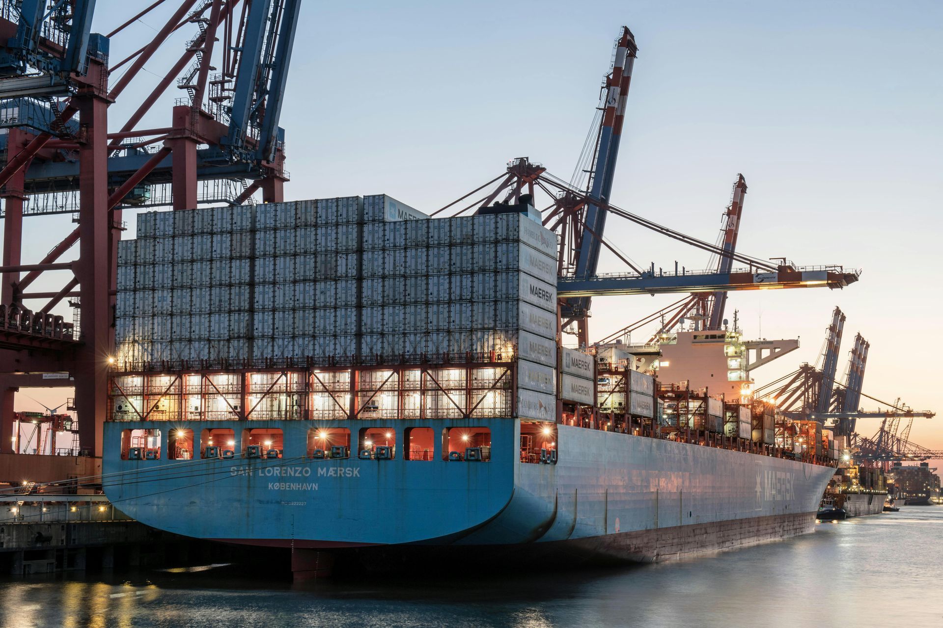 A large container ship is docked in a harbor.