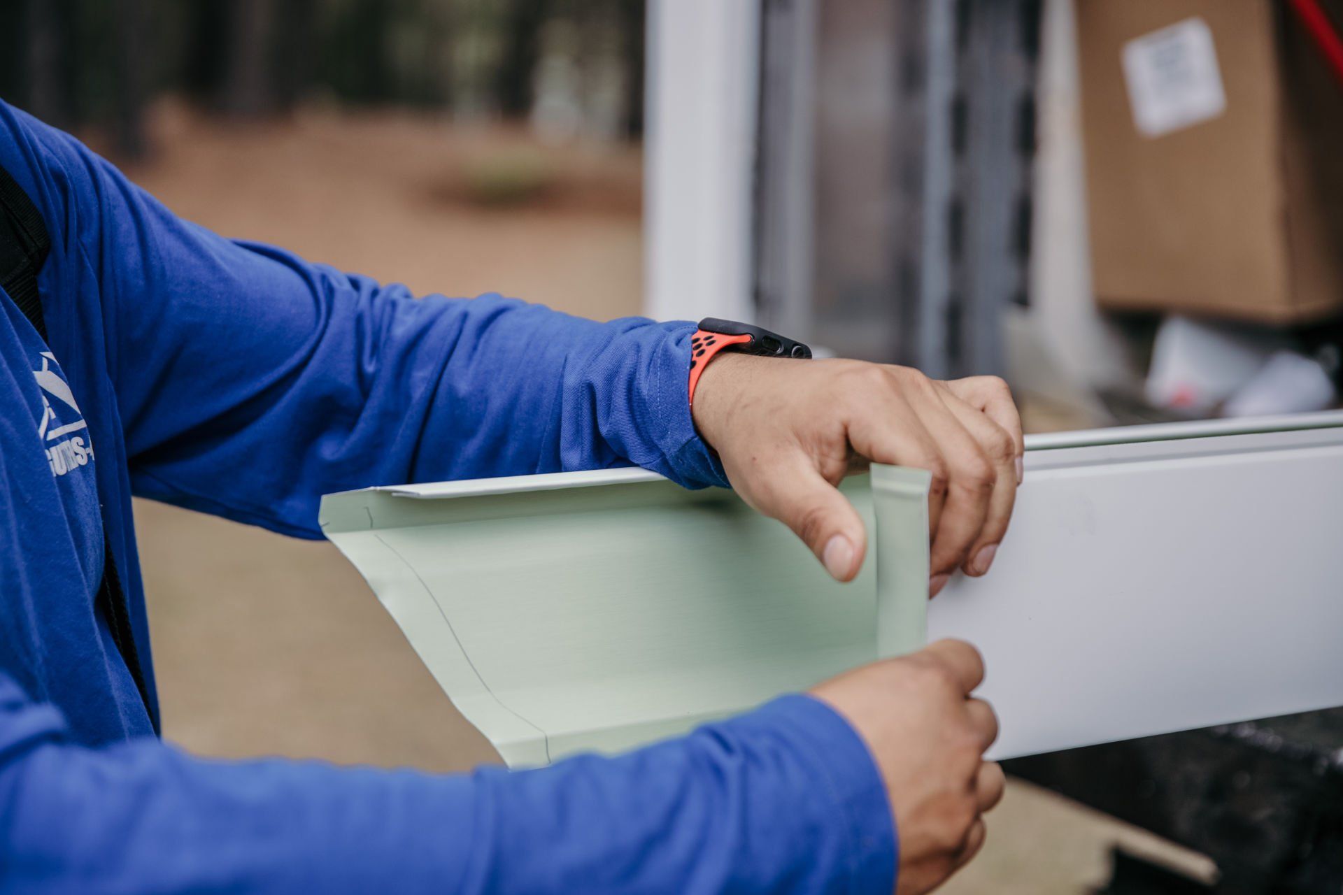 A man in a blue shirt is holding a piece of paper.