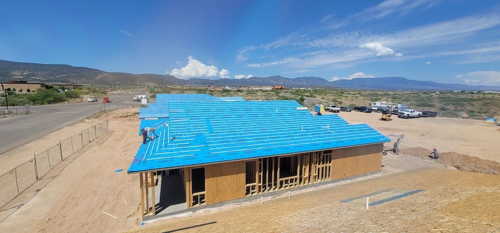 An aerial view of a house under construction with a blue roof.