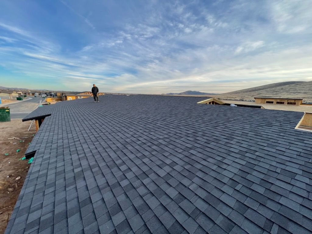 A chimney on the roof of a house with a blue sky in the background.