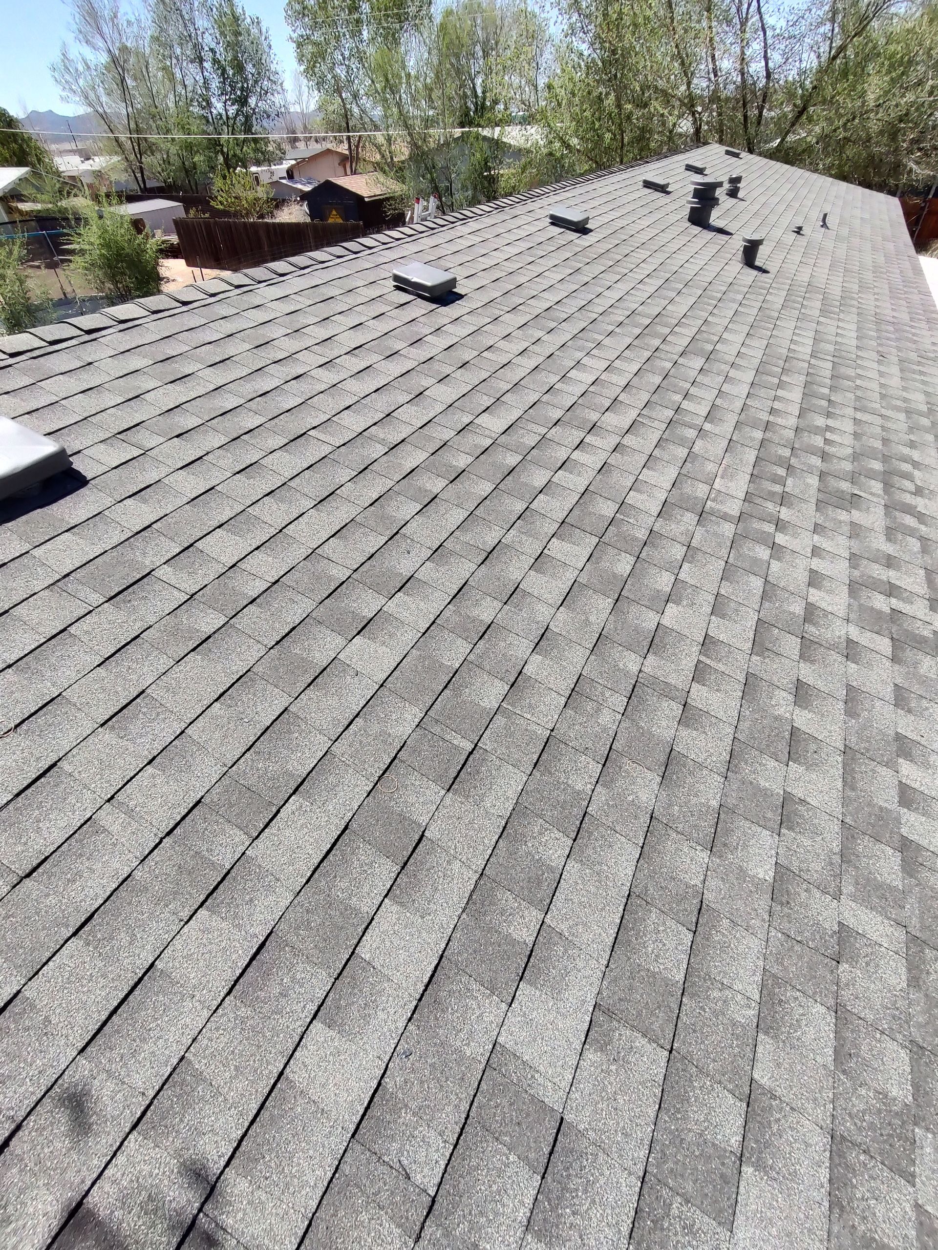 A roof with a lot of shingles and a skylight on it.