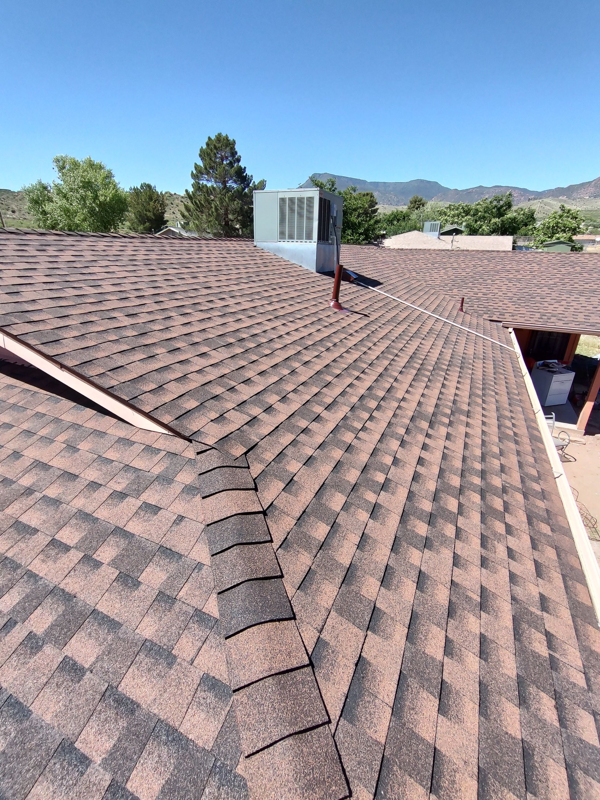 A roof with a lot of shingles on it and a chimney on top of it.