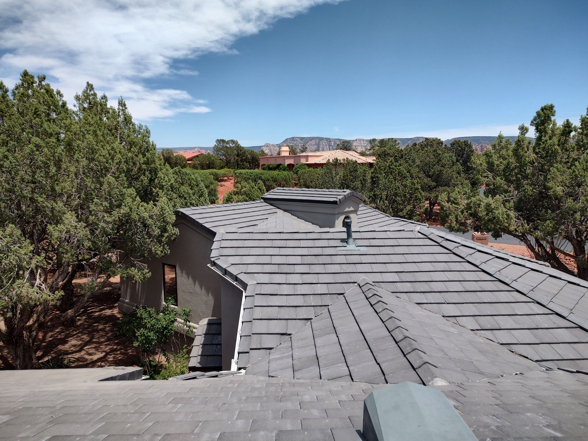 A man is standing on top of a blue roof.