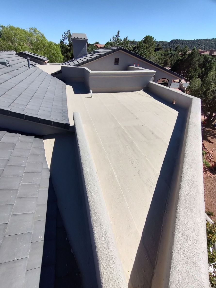 A chimney on the roof of a house with a blue sky in the background.