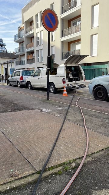 Une camionnette est garée sur le bord de la route à côté d'un panneau d'interdiction de stationnement.