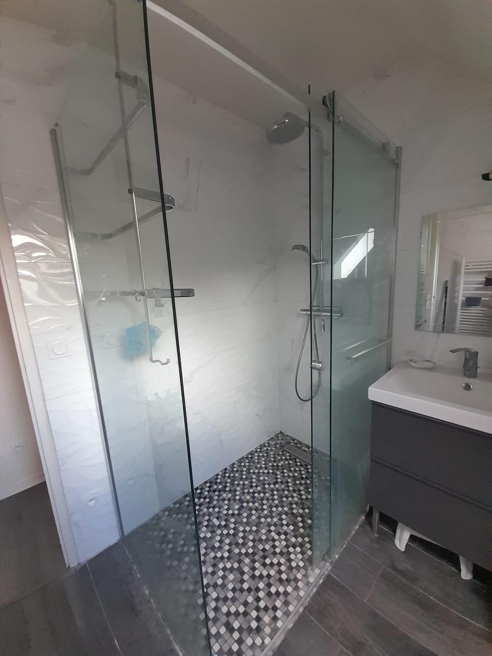 Une salle de bain avec une douche à l'italienne et un lavabo.