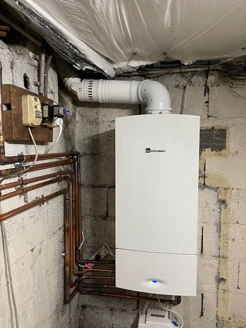 Une chaudière blanche est suspendue au plafond d'une pièce.