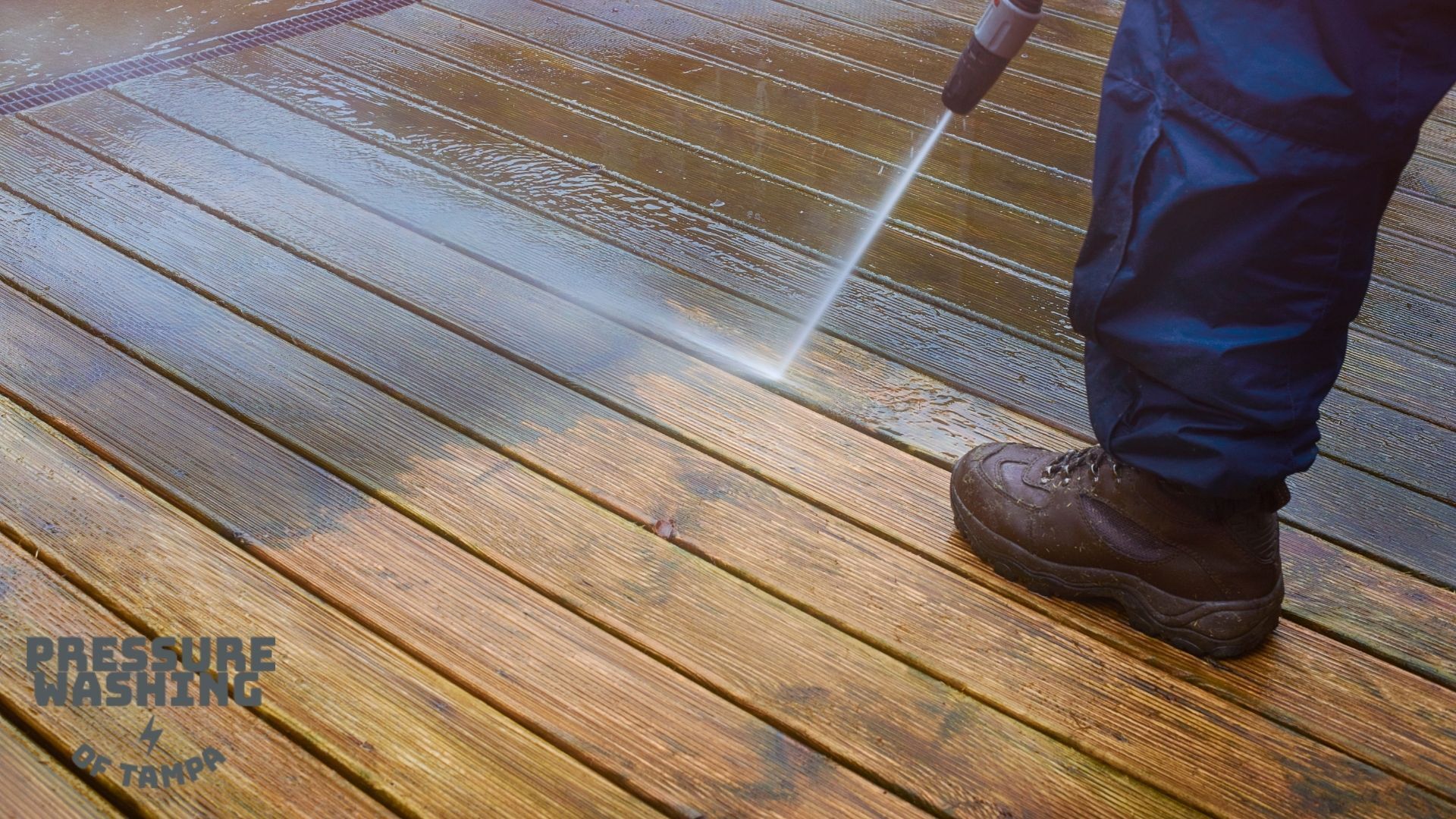 a professional doing pressure washing on a wooden deck at a residential property 