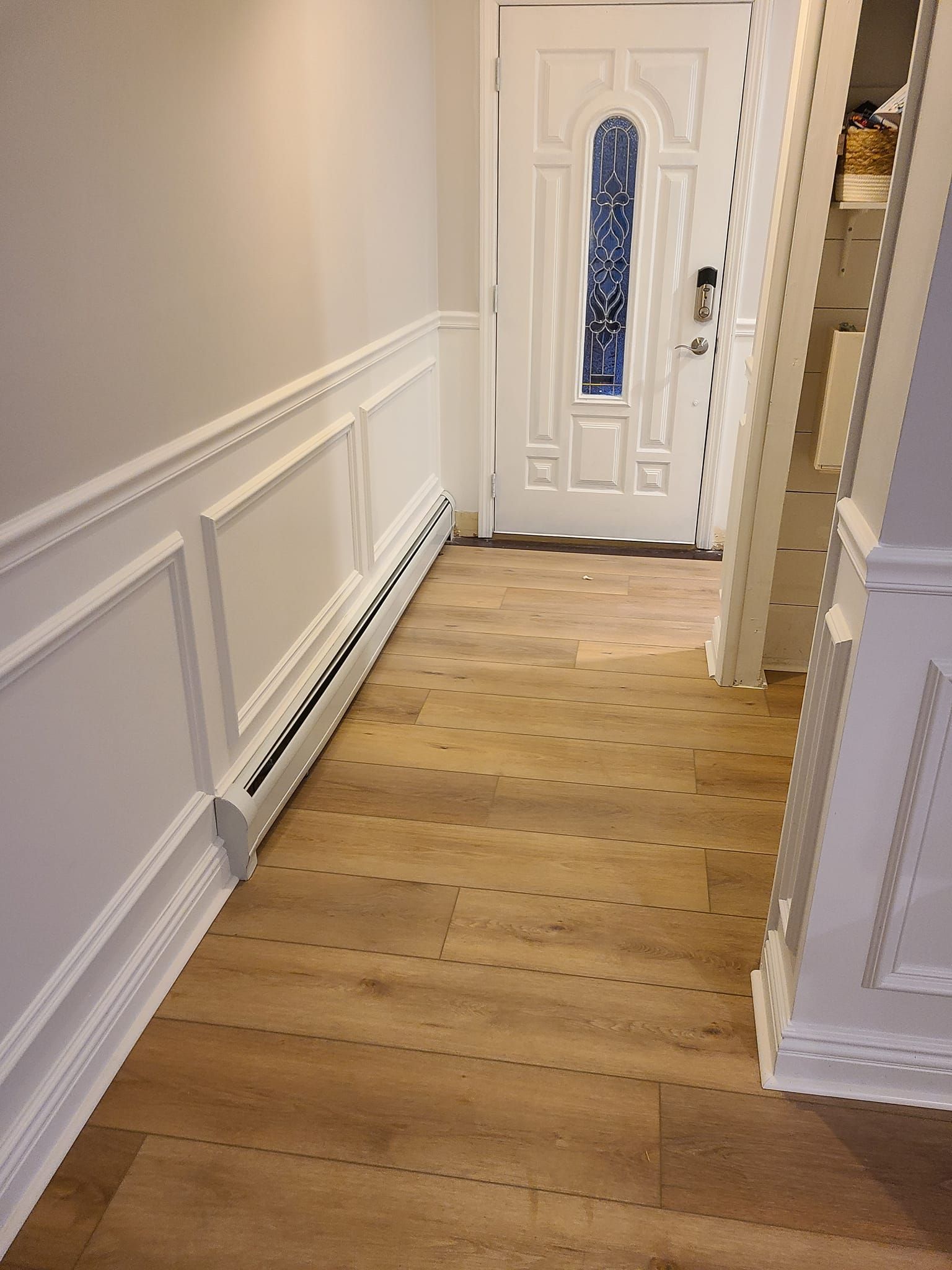 A staircase in a basement with carpeted steps and a white railing.