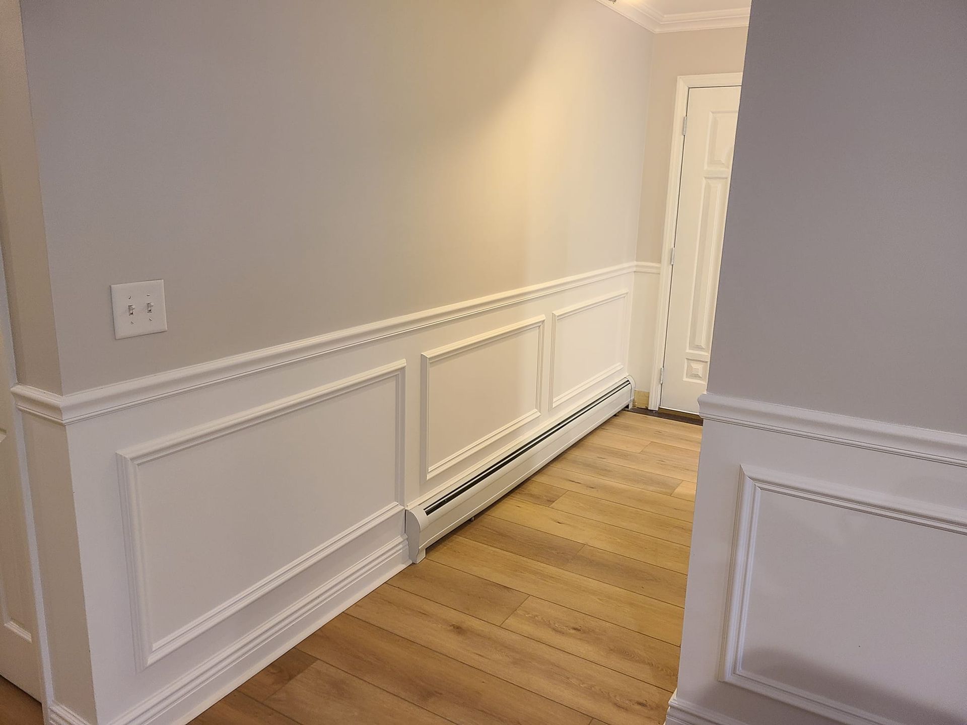 A staircase in a basement with carpeted steps and a white railing.