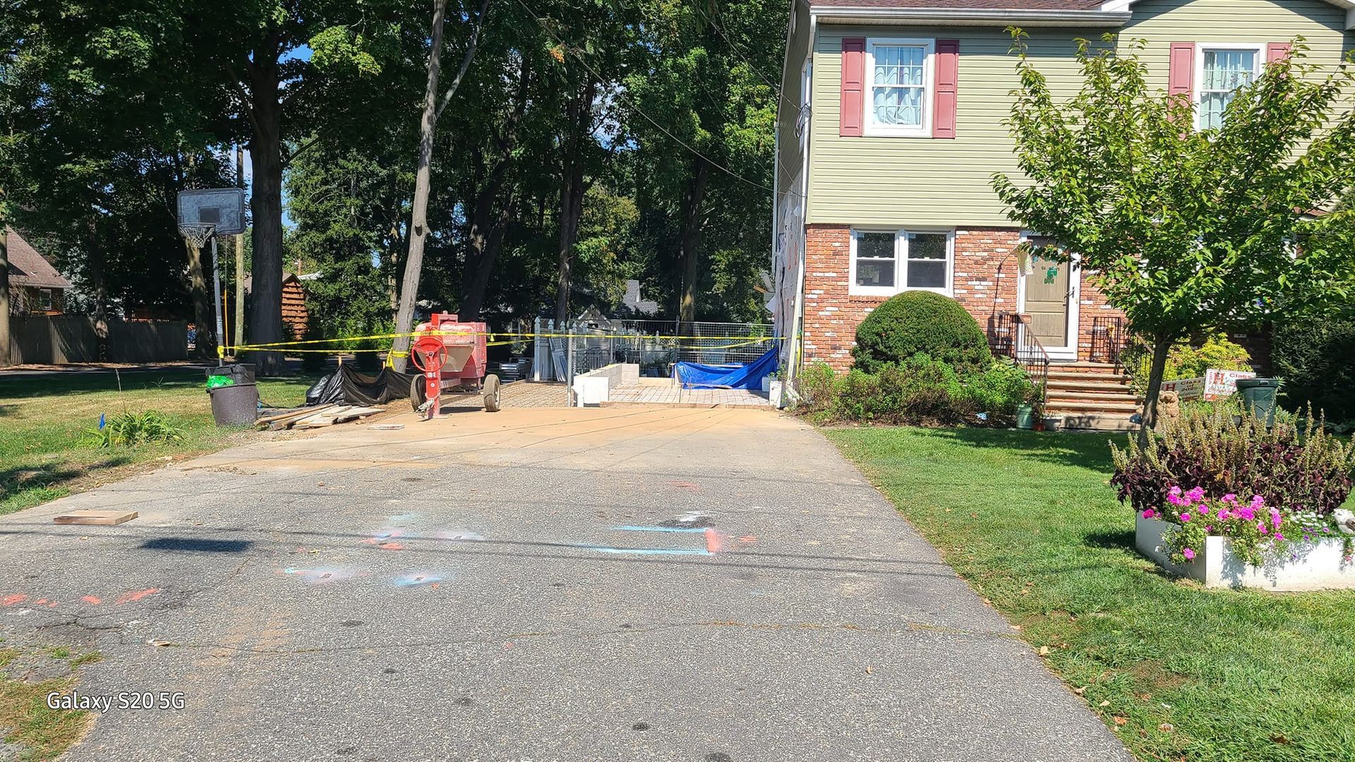 A house with a gravel driveway leading to it is being remodeled.