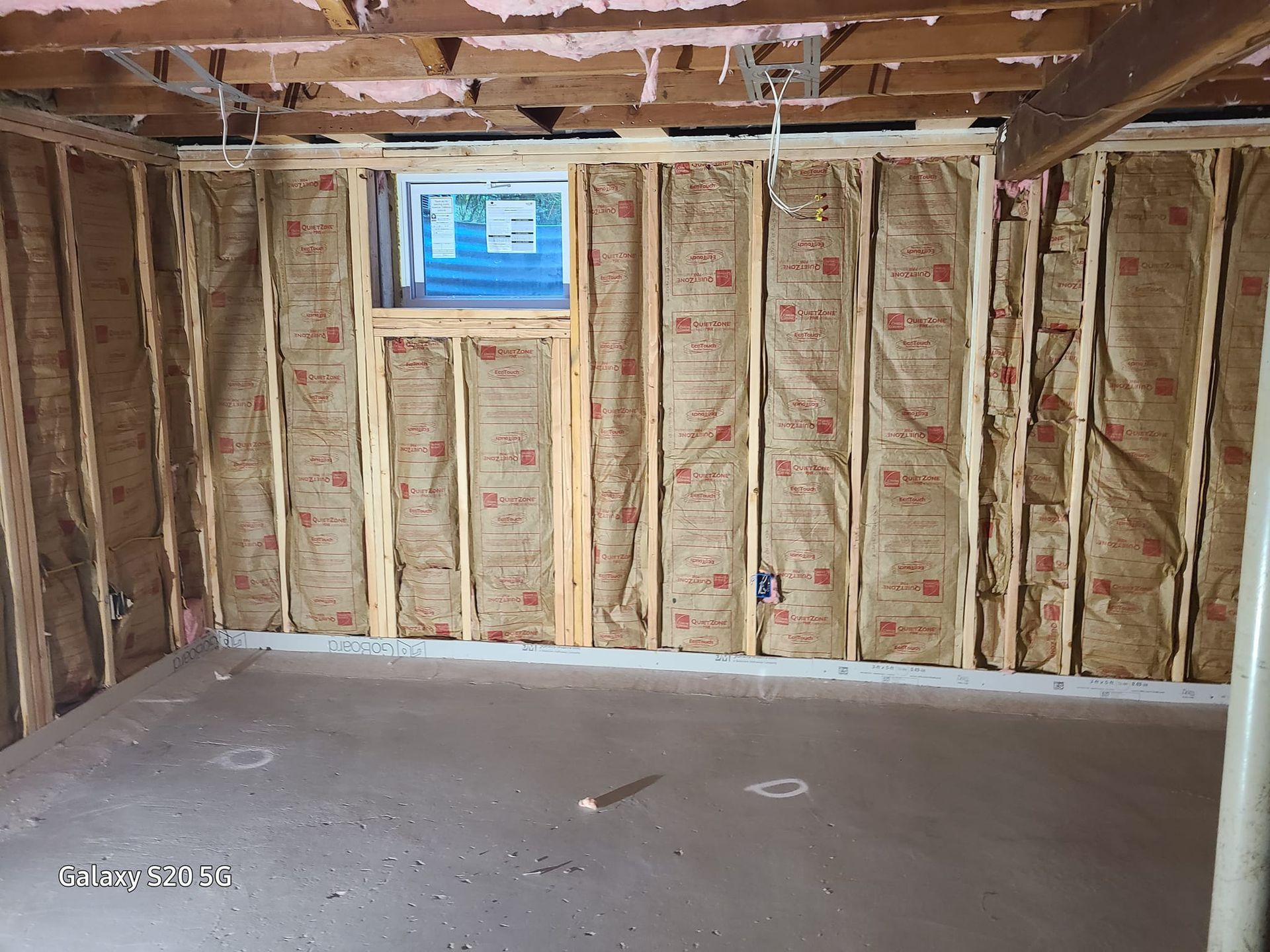 A room with insulation on the walls and a window.