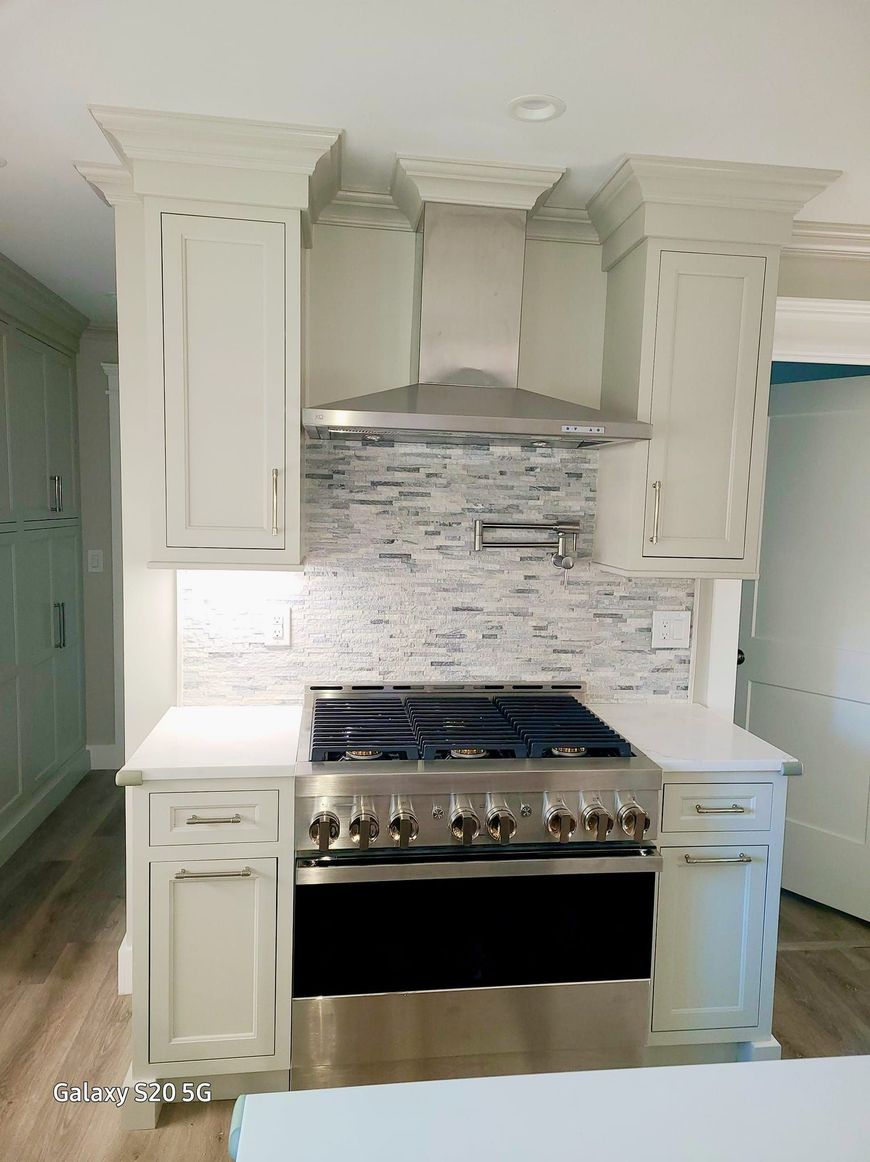 A kitchen with stainless steel appliances and white cabinets.