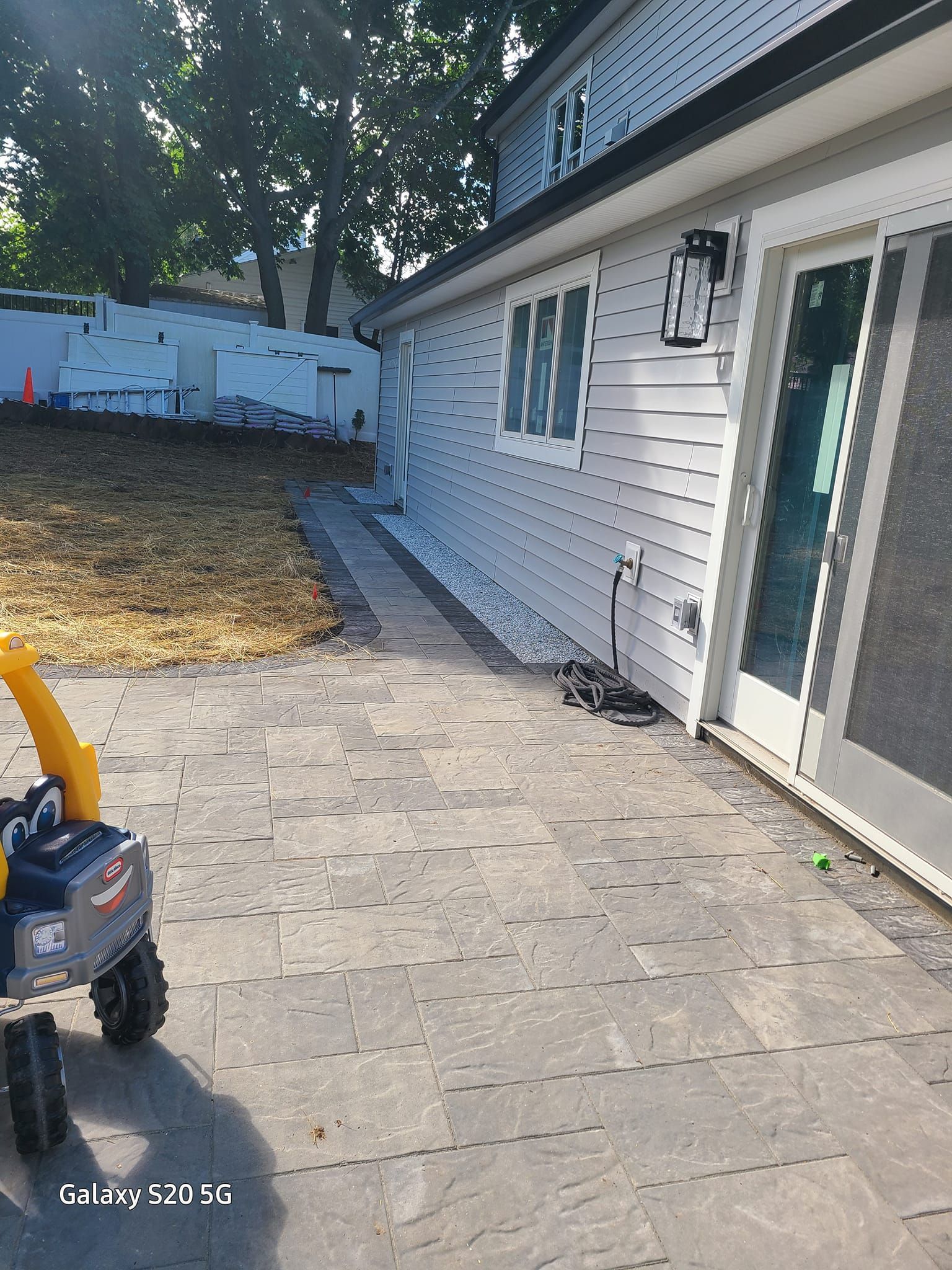 A toy snow blower is parked in front of a house.