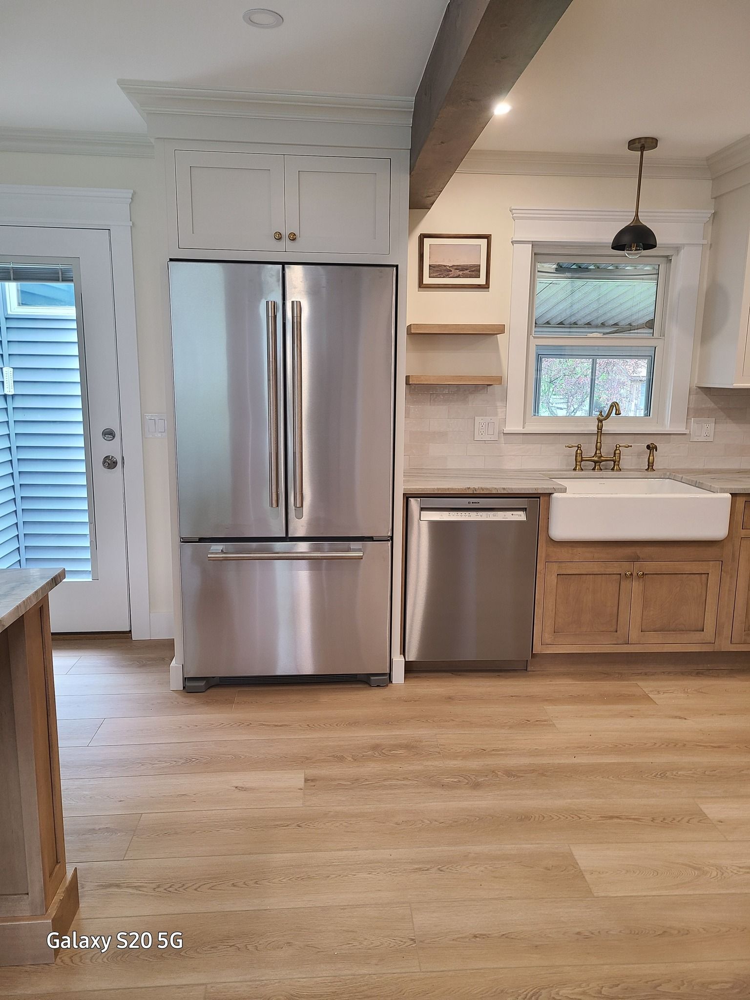 A kitchen with stainless steel appliances and wooden cabinets.