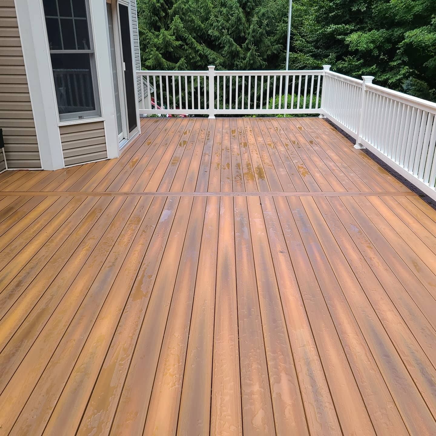 A large wooden deck with a white railing