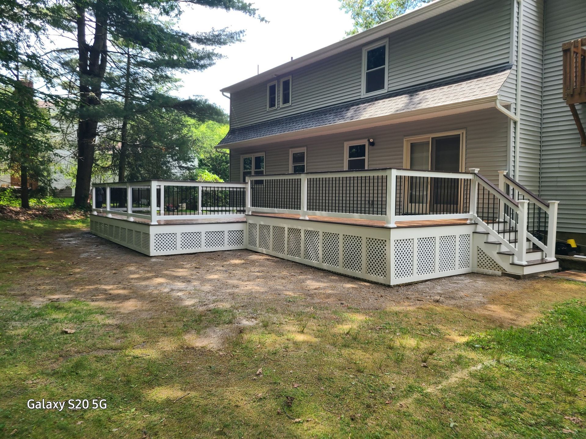 A large house with a large deck and stairs in front of it.