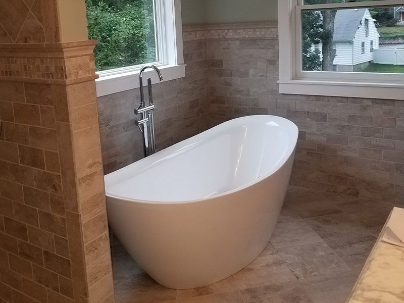 A bathtub is sitting in a bathroom next to a window.