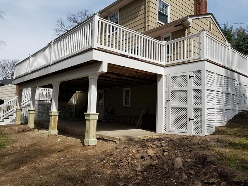 A house with a large deck and a garage underneath it.