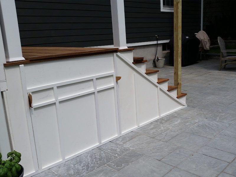 Stairs leading up to a porch with a black house in the background