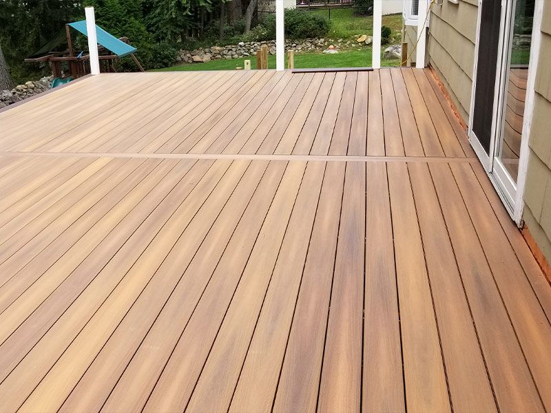 A large wooden deck with a sliding glass door