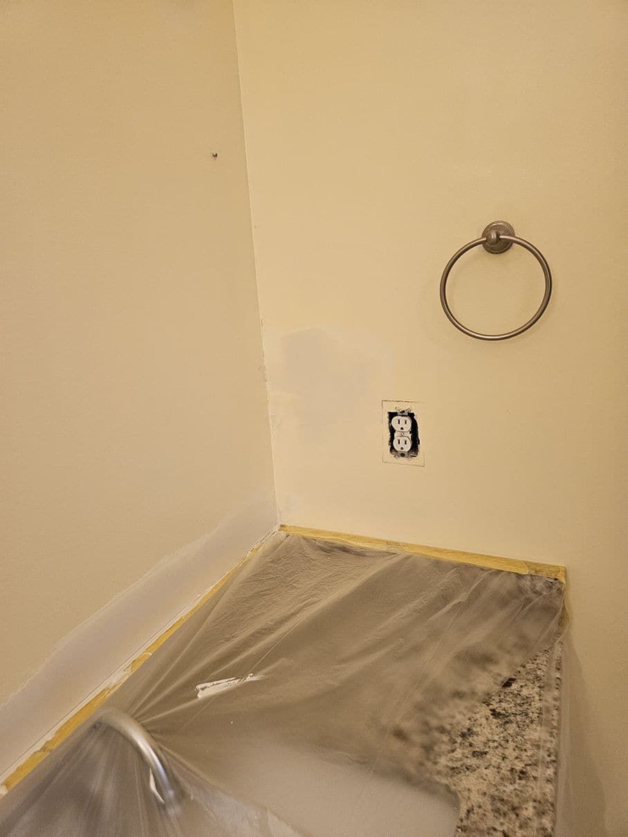 A bathroom with a sink and a towel ring on the wall.