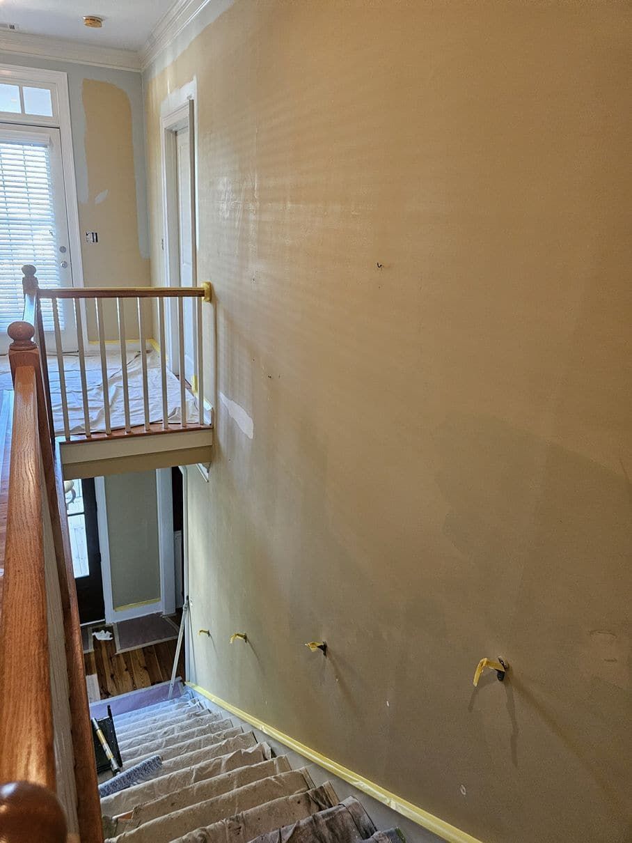 A staircase with a wooden railing leading up to a second floor.
